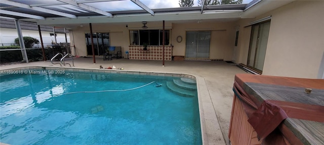 view of swimming pool with a lanai and a patio