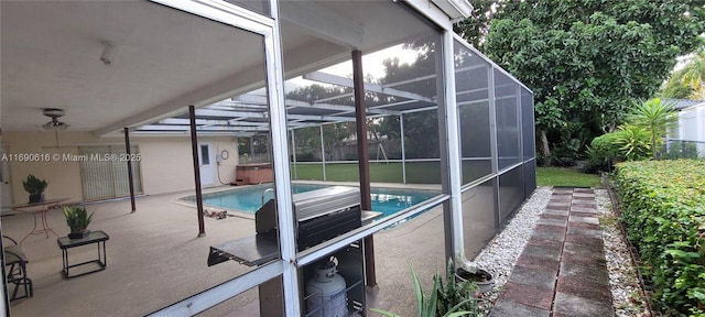 view of pool featuring a hot tub, glass enclosure, and a patio area