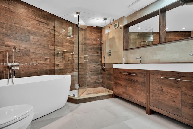 full bathroom featuring toilet, shower with separate bathtub, vanity, and tile walls