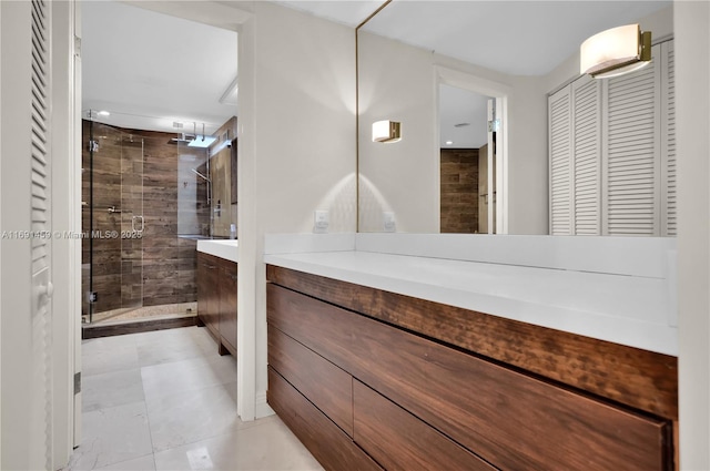 bathroom featuring a shower with shower door and vanity