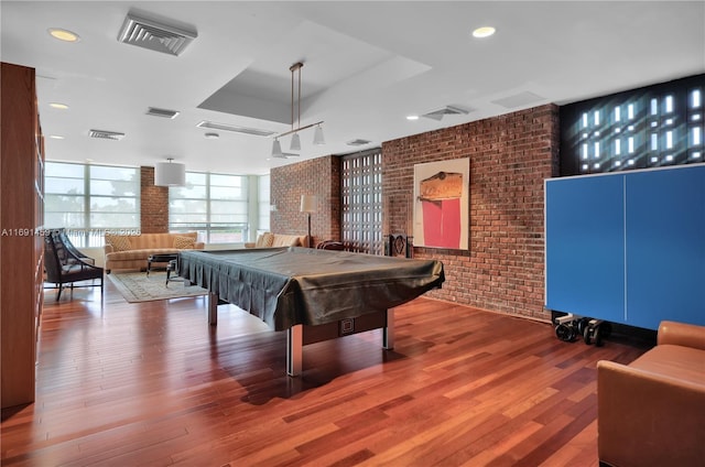 recreation room featuring a wall of windows, wood-type flooring, brick wall, and pool table