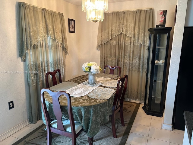 dining area with light tile patterned flooring and a notable chandelier