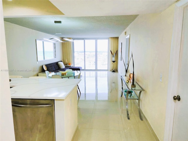 kitchen featuring dishwasher, floor to ceiling windows, a textured ceiling, and light tile patterned floors