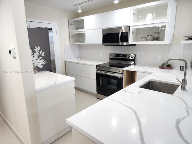 800 SE 20th Ave Unit 1109, Deerfield Beach, FL 33441 - kitchen featuring decorative backsplash, modern cabinets, a sink, white cabinets, and stainless steel appliances
