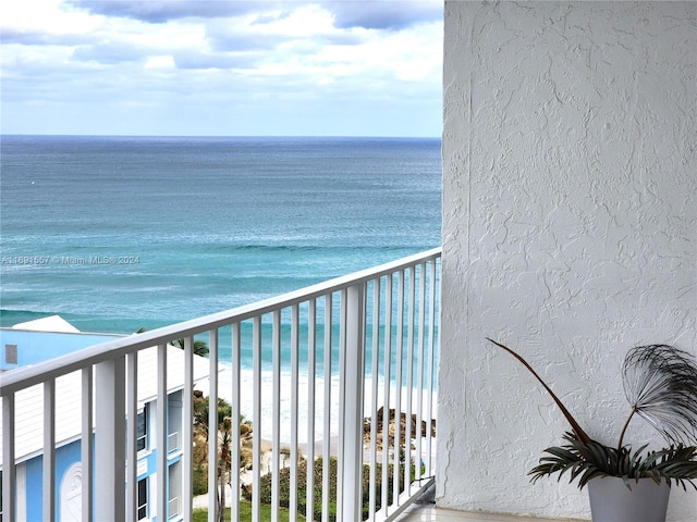 balcony featuring a beach view and a water view