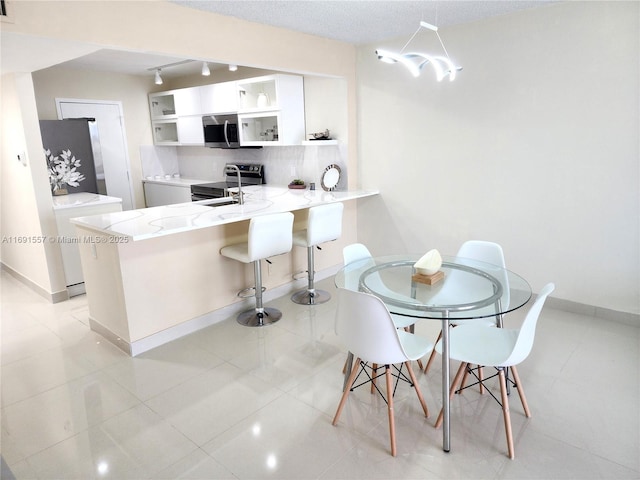 800 SE 20th Ave Unit 1109, Deerfield Beach, FL 33441 - dining space featuring baseboards, independent washer and dryer, rail lighting, and light tile patterned floors