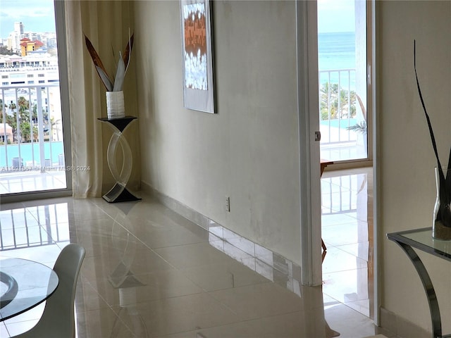 interior space featuring a water view and light tile patterned floors