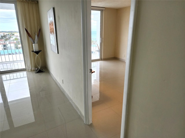 corridor featuring a wealth of natural light and light tile patterned flooring