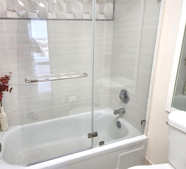 bathroom with enclosed tub / shower combo and toilet