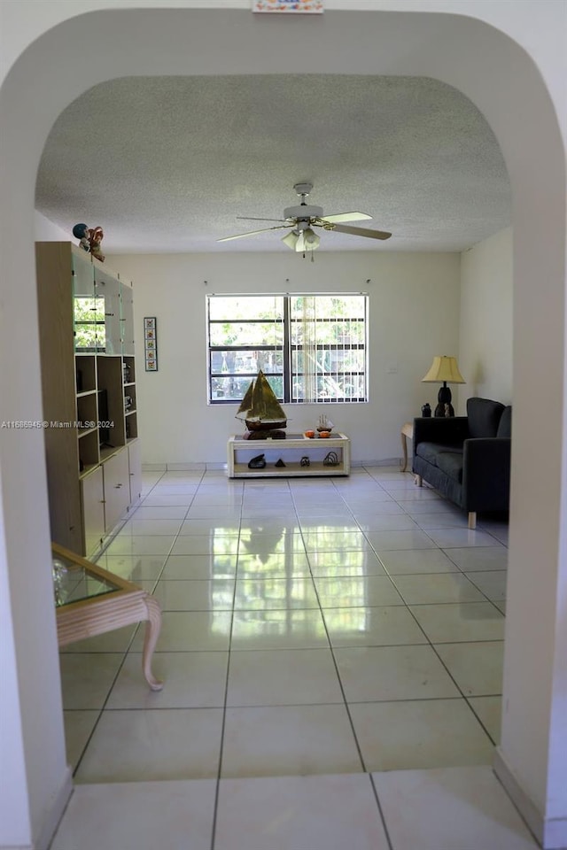 corridor with a textured ceiling and tile patterned floors