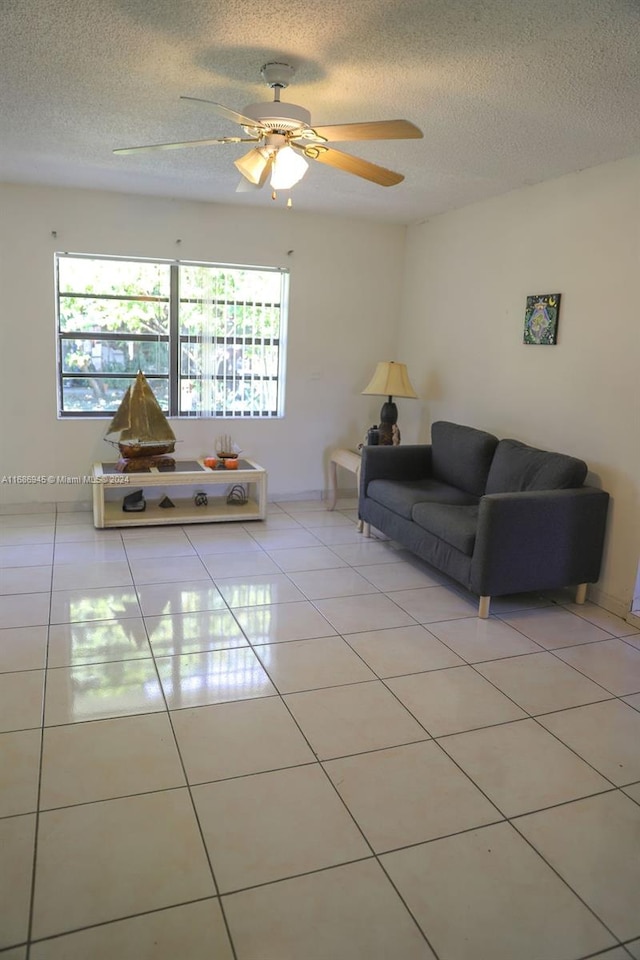 tiled living room featuring a textured ceiling and ceiling fan