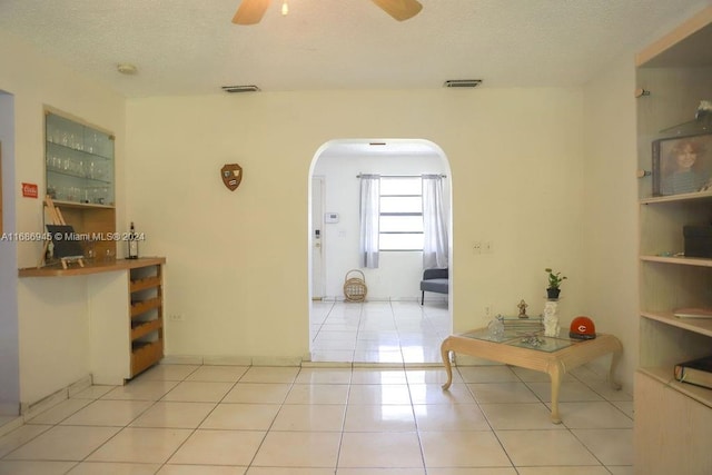 hallway featuring a textured ceiling and light tile patterned floors