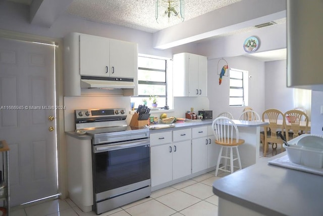 kitchen with stainless steel electric range, a textured ceiling, light tile patterned floors, and white cabinets