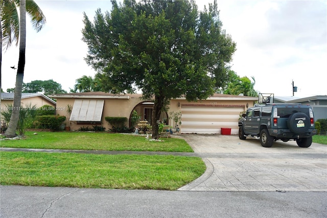 single story home with a garage and a front lawn