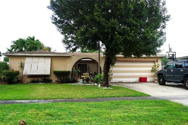 single story home featuring a garage and a front lawn