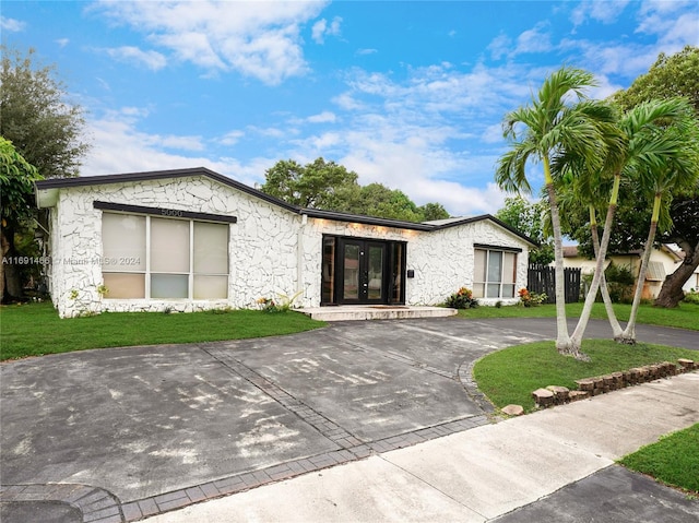 single story home with a front yard and french doors