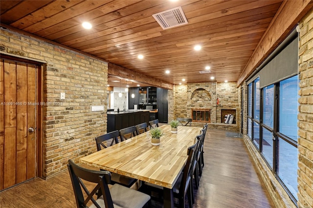 dining area with dark hardwood / wood-style flooring, wooden ceiling, and a fireplace