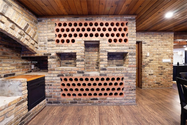 wine room with wooden ceiling, brick wall, and wood-type flooring