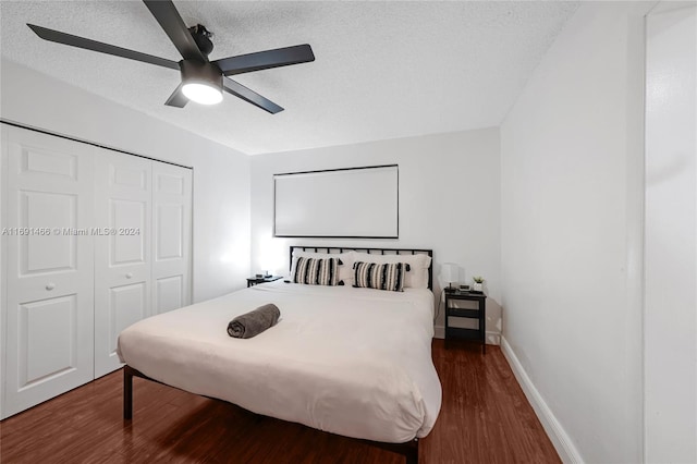 bedroom featuring dark hardwood / wood-style flooring, ceiling fan, a closet, and a textured ceiling