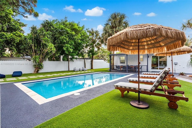 view of swimming pool with a yard