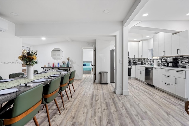 1899 NE 49th Ct, Pompano Beach, FL 33064 - kitchen featuring stainless steel dishwasher, backsplash, light hardwood / wood-style floors, and white cabinets