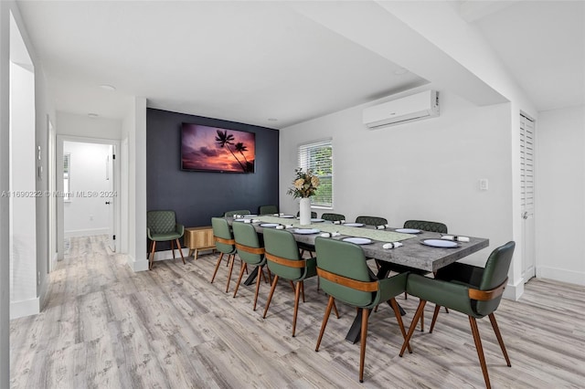 dining room featuring a wall mounted air conditioner and light hardwood / wood-style flooring