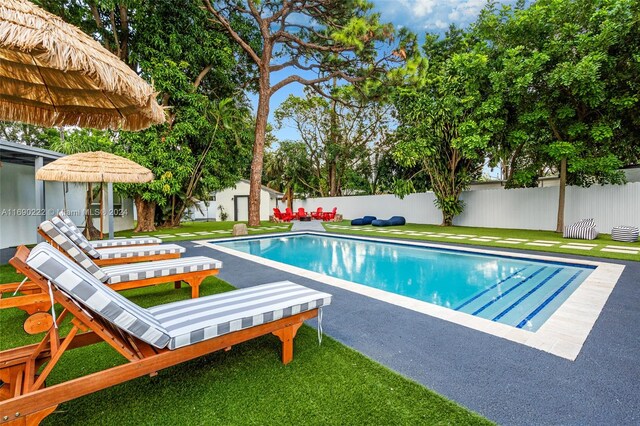 1899 NE 49th Ct, Pompano Beach, FL 33064 - view of swimming pool featuring a lawn and a patio area