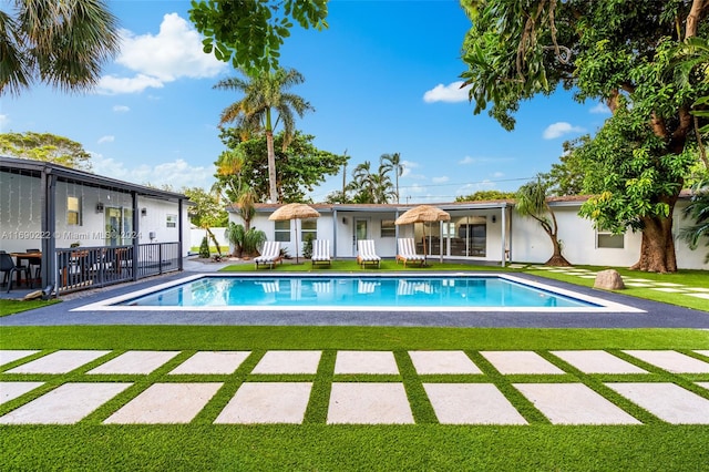 view of pool featuring a lawn and a patio area