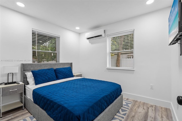 bedroom featuring an AC wall unit and hardwood / wood-style floors