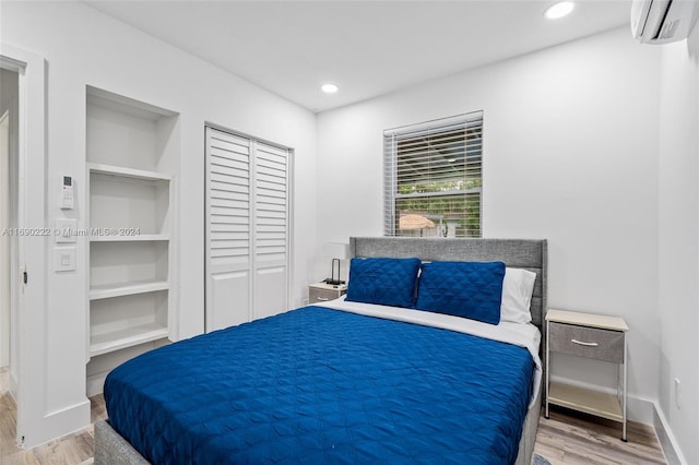 bedroom with a wall unit AC and hardwood / wood-style flooring