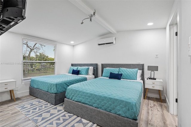 bedroom with light wood-type flooring, a wall unit AC, and lofted ceiling with beams