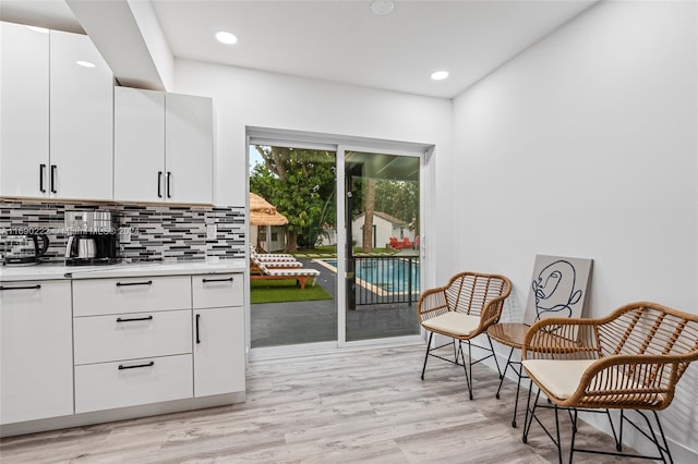 kitchen with white cabinetry, light hardwood / wood-style flooring, and decorative backsplash