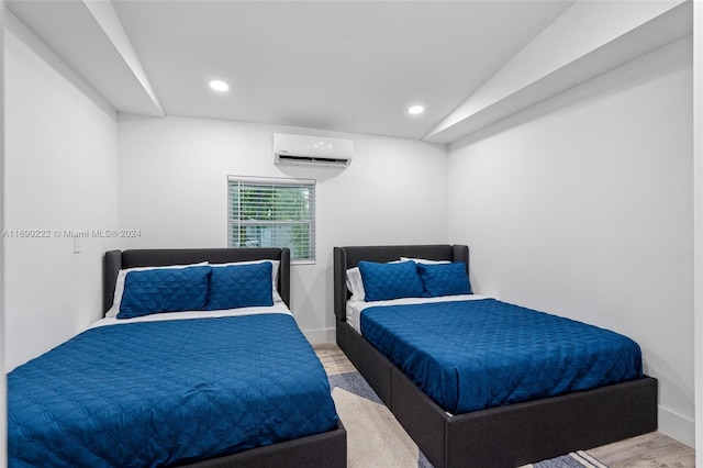 bedroom featuring hardwood / wood-style floors, a wall unit AC, and lofted ceiling