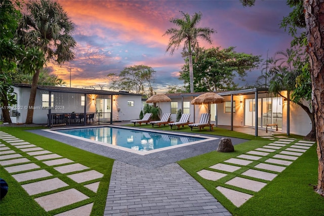 1899 NE 49th Ct, Pompano Beach, FL 33064 - pool at dusk featuring a yard and a patio