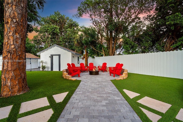 yard at dusk with an outbuilding and an outdoor fire pit