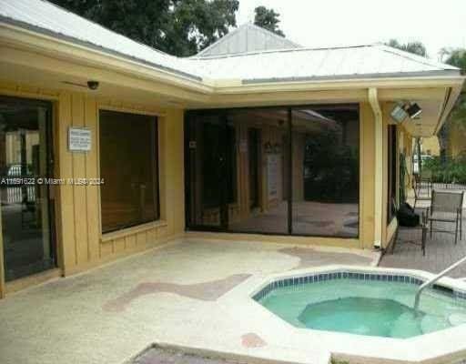 back of house featuring a patio and an in ground hot tub