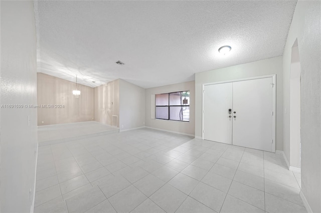 tiled empty room with a textured ceiling