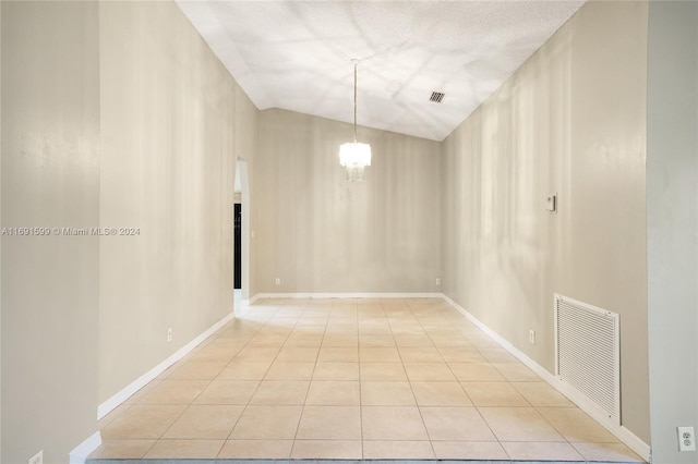 tiled empty room with lofted ceiling, a textured ceiling, and a chandelier