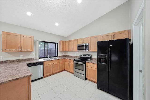 kitchen with light tile patterned flooring, stainless steel appliances, lofted ceiling, and sink