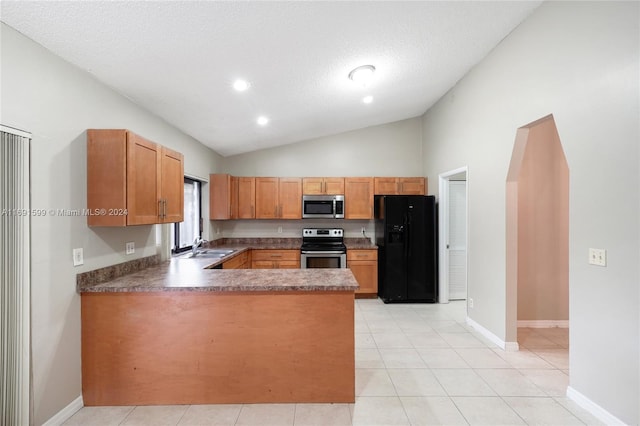 kitchen featuring appliances with stainless steel finishes, a textured ceiling, lofted ceiling, and light tile patterned flooring