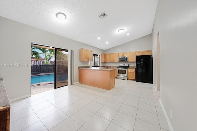 kitchen with kitchen peninsula, appliances with stainless steel finishes, a textured ceiling, lofted ceiling, and light tile patterned flooring