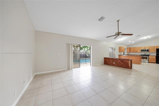 kitchen featuring appliances with stainless steel finishes, a textured ceiling, vaulted ceiling, ceiling fan, and light tile patterned flooring