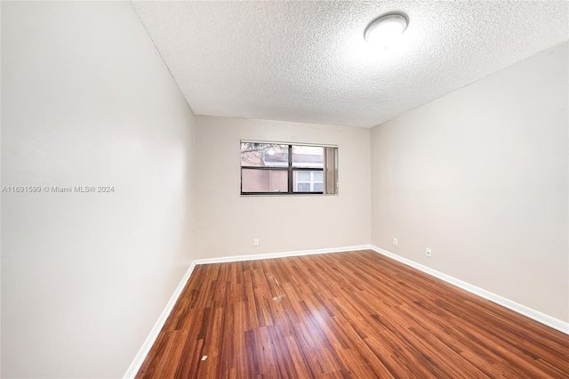 unfurnished room with hardwood / wood-style floors and a textured ceiling