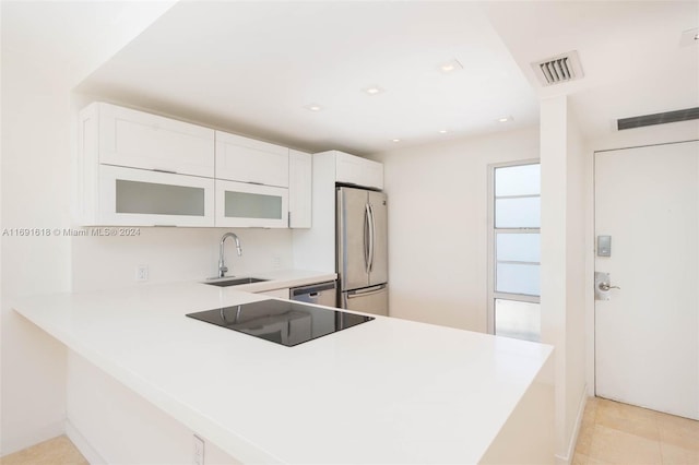 kitchen with stainless steel appliances, light tile patterned flooring, sink, kitchen peninsula, and white cabinets