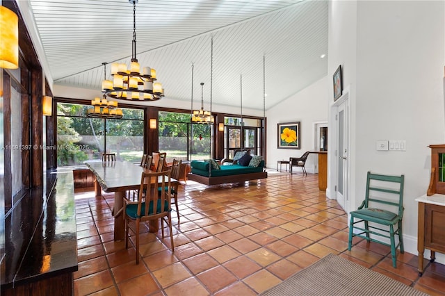 dining area with high vaulted ceiling, baseboards, tile patterned floors, and a notable chandelier