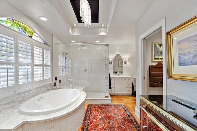 bathroom featuring tile patterned floors, vanity, shower with separate bathtub, and a notable chandelier