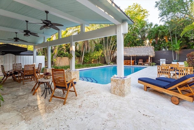 view of swimming pool featuring ceiling fan and a patio