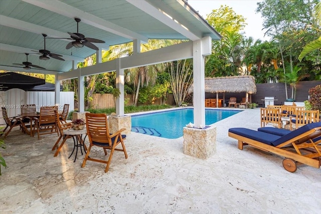 view of pool with a fenced backyard, a fenced in pool, an outbuilding, a patio area, and a ceiling fan