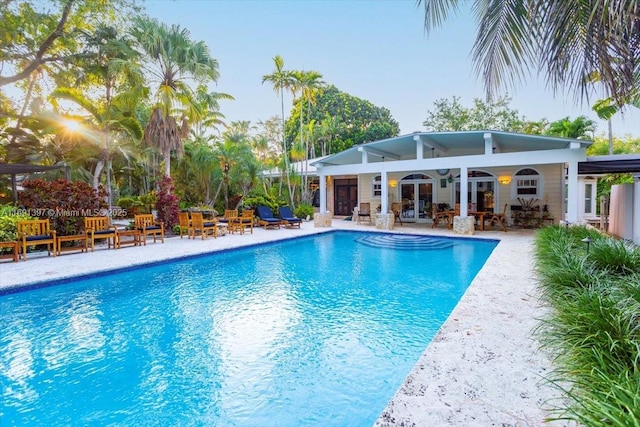 pool featuring outdoor lounge area, french doors, and a patio area