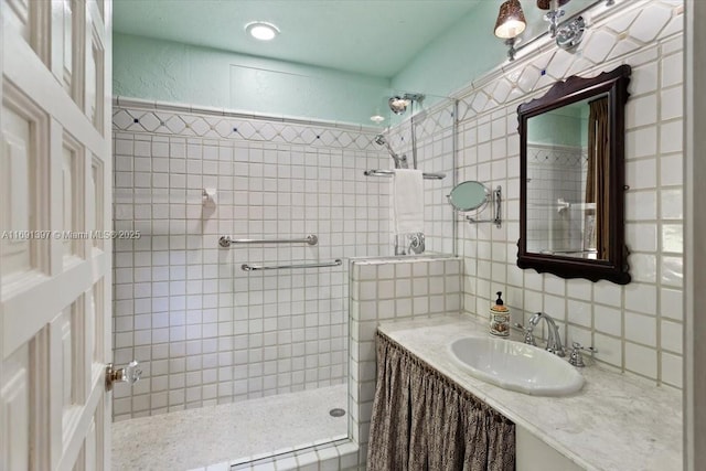 full bath with vanity, tile walls, a tile shower, and tasteful backsplash